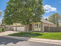 A charming single-Gathering home with a well-manicured lawn and mature trees adding curb appeal at 1649 Iris St, Broomfield, CO 80020