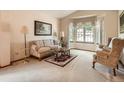 Cozy living room with a bay window, patterned sofa, and classic decor creating a welcoming ambiance at 1649 Iris St, Broomfield, CO 80020
