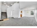 Bright living room featuring plush gray carpet, tall ceilings, and natural light from multiple windows at 11963 Dahlia Dr, Thornton, CO 80233
