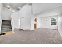Bright living room featuring neutral carpet, high ceilings, and staircase at 11963 Dahlia Dr, Thornton, CO 80233