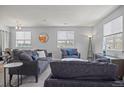 Bright living room featuring neutral walls, plush gray sofas, and ample natural light from multiple windows at 3228 W Girard Ave # C, Englewood, CO 80110