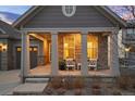 Charming front porch with stone pillars, white chairs, and a welcoming entrance, highlighting the home's curb appeal at 8751 S Wenatchee Ct, Aurora, CO 80016
