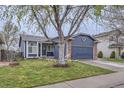 Charming blue home with a two-car garage, brick accents, and a well-maintained lawn at 5550 E 130Th Dr, Thornton, CO 80241