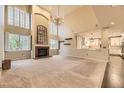 Spacious living room with fireplace, high ceilings, and windows overlooking the yard at 5660 E Burlington Dr, Castle Rock, CO 80104