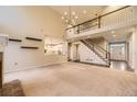 Open-concept living room featuring a staircase, large windows, and access to the kitchen at 5660 E Burlington Dr, Castle Rock, CO 80104