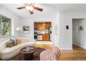 Cozy living room with an open floor plan, ceiling fan, and hardwood floors is adjacent to kitchen at 2100 N Franklin St # 5, Denver, CO 80205