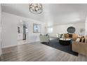 Bright living room with modern light fixture, wood floors, and comfortable seating arrangement at 2538 S Dover Way, Lakewood, CO 80227