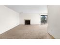 Spacious carpeted living room with a fireplace and a sliding glass door to the balcony at 3041 S Ursula Cir # 302, Aurora, CO 80014