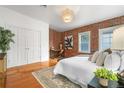 Inviting bedroom with exposed brick wall, hardwood floors, and ample natural light at 624 E 18Th Ave # 4, Denver, CO 80203