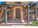 A welcoming entryway that features an attractive brick facade, a sturdy wooden door, and decorative exterior lighting at 1418 Glencoe St, Denver, CO 80220