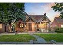 Charming brick home featuring a well-manicured lawn, beautiful landscaping, and a cozy front porch with outdoor seating at 1418 Glencoe St, Denver, CO 80220