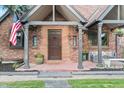 Inviting covered front porch with brick facade, seating area, and a welcoming ambiance at 1418 Glencoe St, Denver, CO 80220