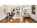 Bright living room with hardwood floors, a fireplace, and natural light from large windows at 1418 Glencoe St, Denver, CO 80220