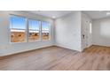 Bright living room featuring three large windows providing stunning views and natural light at 16777 W 94Th Way, Arvada, CO 80007