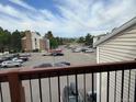 View from the balcony overlooking the parking lot with several cars, community buildings, and distant mountains at 8645 Clay St # 400, Westminster, CO 80031