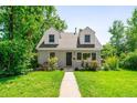 Charming two-story home with landscaped yard and a classic walkway to the front door at 1856 S Monroe St, Denver, CO 80210