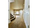 Welcoming front entryway with carpet flooring, stairs to the left, and a bright living room at 6102 S Yampa St, Aurora, CO 80016