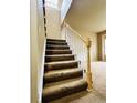 Carpeted staircase featuring a wooden railing leading to the upper level of the home at 6102 S Yampa St, Aurora, CO 80016