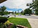 Street view showcasing the front yard, neighborhood surroundings, and community green space at 6102 S Yampa St, Aurora, CO 80016
