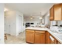 Bright kitchen with wooden cabinets, white appliances, and an open layout leading to other rooms at 4710 N Foxtail Dr, Castle Rock, CO 80109
