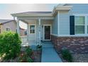 Charming home exterior with front porch, brick accents, and well-manicured landscaping at 3678 Shadow Cir, Castle Rock, CO 80109