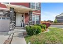 Inviting front porch with stone pillars and landscaped yard, creating a warm welcome at 23593 E Chenango Pl, Aurora, CO 80016