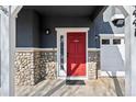 Close up on the red front door with stone accents and white trim at 14441 E 102Nd Ave, Commerce City, CO 80022