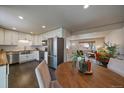 Open-concept kitchen and dining area with modern stainless steel appliances and stylish decor at 6026 Iris Way, Arvada, CO 80004