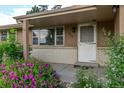 Close up of front entrance with an exterior brick accent, pretty flowering plants, and covered entry at 6131 Wolff St, Arvada, CO 80003