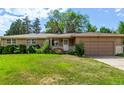 Inviting single-story home with a well-maintained lawn, lovely landscaping, and an attached garage at 6131 Wolff St, Arvada, CO 80003