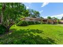 Charming single-story home with a well-manicured lawn, mature trees providing plenty of shade at 6131 Wolff St, Arvada, CO 80003