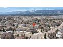 Aerial view of a two-story home in a neighborhood with mountain views on a sunny day at 15640 Agate Creek Dr, Monument, CO 80132