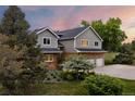 Two-story home with attached three car garage, with brick and siding and a well maintained yard at 7883 S Espana Way, Centennial, CO 80016