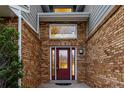 Close up of front door with sidelights and brick facade and well kept landscaping at 7883 S Espana Way, Centennial, CO 80016
