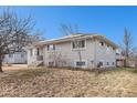 Side view of a ranch home showcasing its brick exterior and landscaping at 4675 Reed St, Wheat Ridge, CO 80033