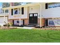 Welcoming entrance with black double doors, brick accents, and manicured landscaping at 3785 S Benton Way, Denver, CO 80235