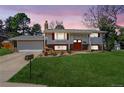 Charming home with mature trees, green lawn, colorful flower beds, and a cozy front porch at 3785 S Benton Way, Denver, CO 80235