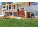 Inviting home featuring a brick facade, colorful front door, and manicured lawn at 3785 S Benton Way, Denver, CO 80235