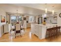 Bright, open kitchen featuring a large island, modern appliances, and an adjacent dining area at 3785 S Benton Way, Denver, CO 80235