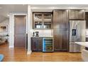 Kitchen area featuring a wine cooler, dark wood cabinets, stainless steel refrigerator, and white marble backsplash at 4625 W 50Th Ave # 309, Denver, CO 80212