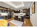 A kitchen featuring dark wood cabinets, stainless steel appliances, a central island, and a built-in wine cooler at 4625 W 50Th Ave # 309, Denver, CO 80212