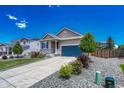 Lovely home with gray siding, stone accents, a two-car garage, and a well-manicured front yard with mature trees at 177 Vista Cliff Cir, Castle Rock, CO 80104