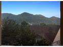 Scenic mountain views from a bright window overlooking treetops and rooftops at 10448 Kicking Horse Dr, Littleton, CO 80125