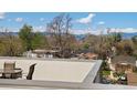 Rooftop patio offers serene views of trees and distant mountains under a blue sky at 4917 Lowell Blvd # 105, Denver, CO 80221