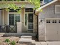 Inviting front entry showcasing brick accents, a secure storm door, and well-manicured landscaping at 6583 W Gould Dr, Littleton, CO 80123