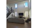 Open-concept living room with high ceilings and a large comfortable gray couch at 6332 E 142Nd Pl, Thornton, CO 80602