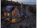 Stunning mountain home with a wrap-around deck, walls of windows, and solar panels, nestled in a serene wooded setting at 13452 Riley Peak Rd, Conifer, CO 80433
