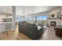 Bright open-concept living room with modern decor, fireplace, and access to outdoor views at 3293 Offbeaten Pl, Castle Rock, CO 80108