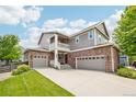Charming two-story home with brick and siding, three-car garage, covered porch and a well-maintained front lawn at 17020 E 107Th Ave, Commerce City, CO 80022