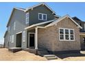 Side view of a two-story home featuring a stone and siding exterior, complemented by a covered porch at 3295 N Coolidge Way, Aurora, CO 80019